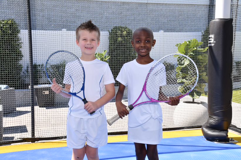 Landon and London on a tennis court